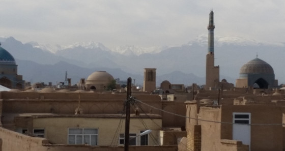 Schneebedeckte Berge im Hintergrund der Wüstenstadt Yazd
